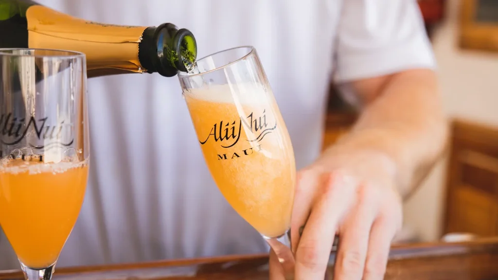 Luxury catamaran sailing at sunset in Maui with champagne service for private charter guests