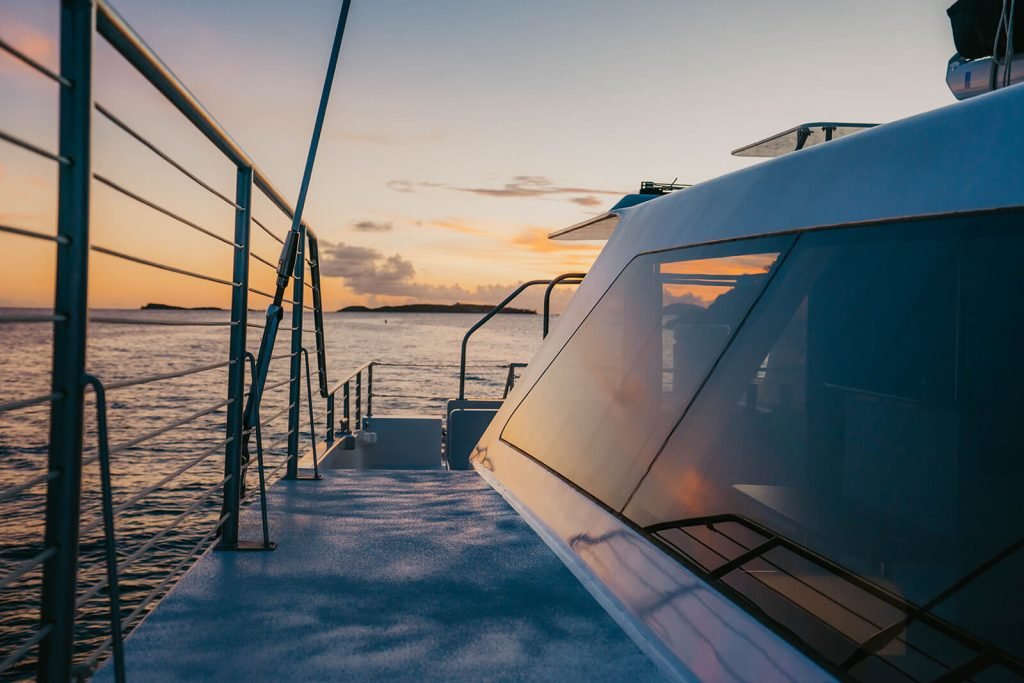 Sunset sailing on a catamaran cruise with beautiful evening view over the water.