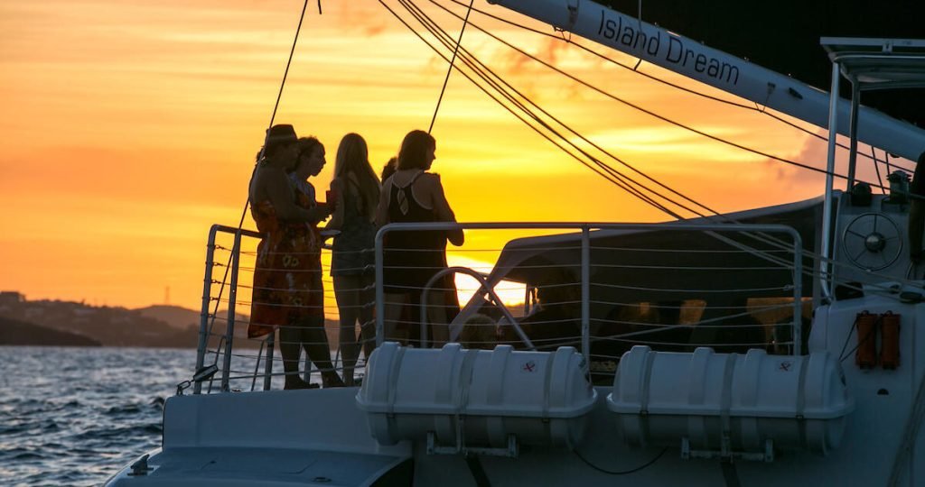 Sunset sail aboard the catamaran 'Island Dream' with glowing skies in the background