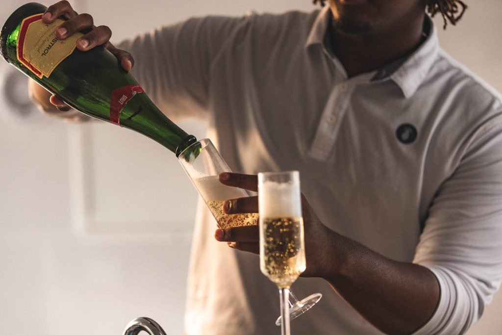 Person Handing A Glass Of Beer On A Cruise Boat With Ocean View.