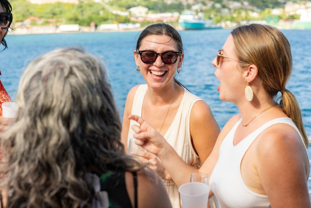 Group Of People Socializing With Drinks By The Seaside.