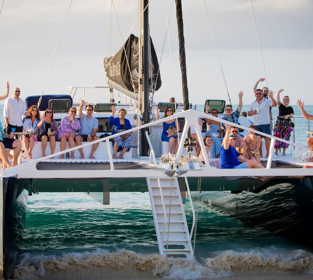 Group enjoying a private charter on VanDutch yacht 'Lady Luxe' in turquoise waters